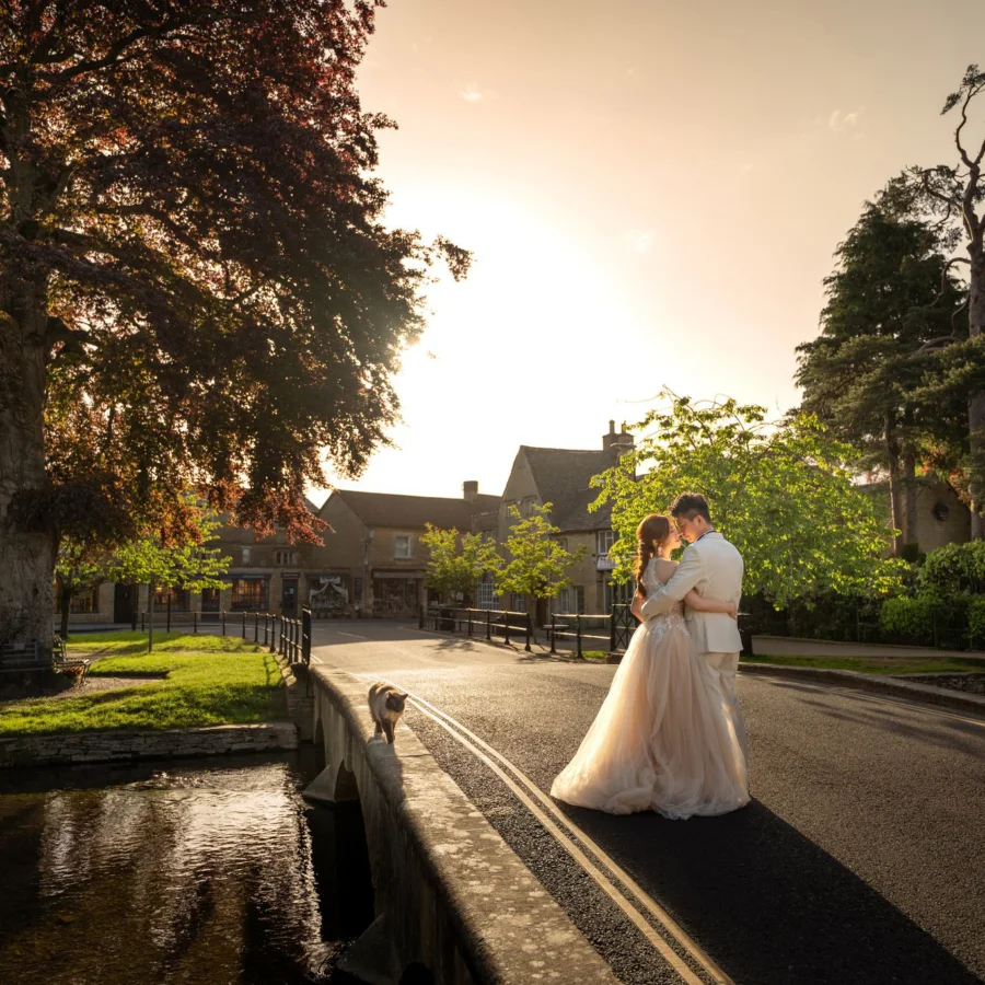 Yan & Victor embracing beside the river beneath a great copper beech at golden hour, Cotswolds village — Cotswolds pre-wedding by Kenn Photographic Arts