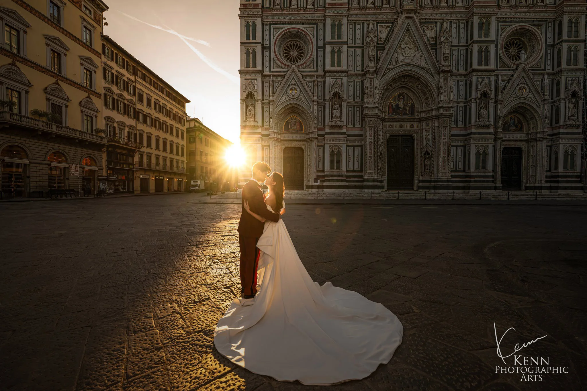 Wincy & Leo embracing as the sun bursts beside the Florence Cathedral façade — Florence & Tuscany pre-wedding by Kenn Photographic Arts