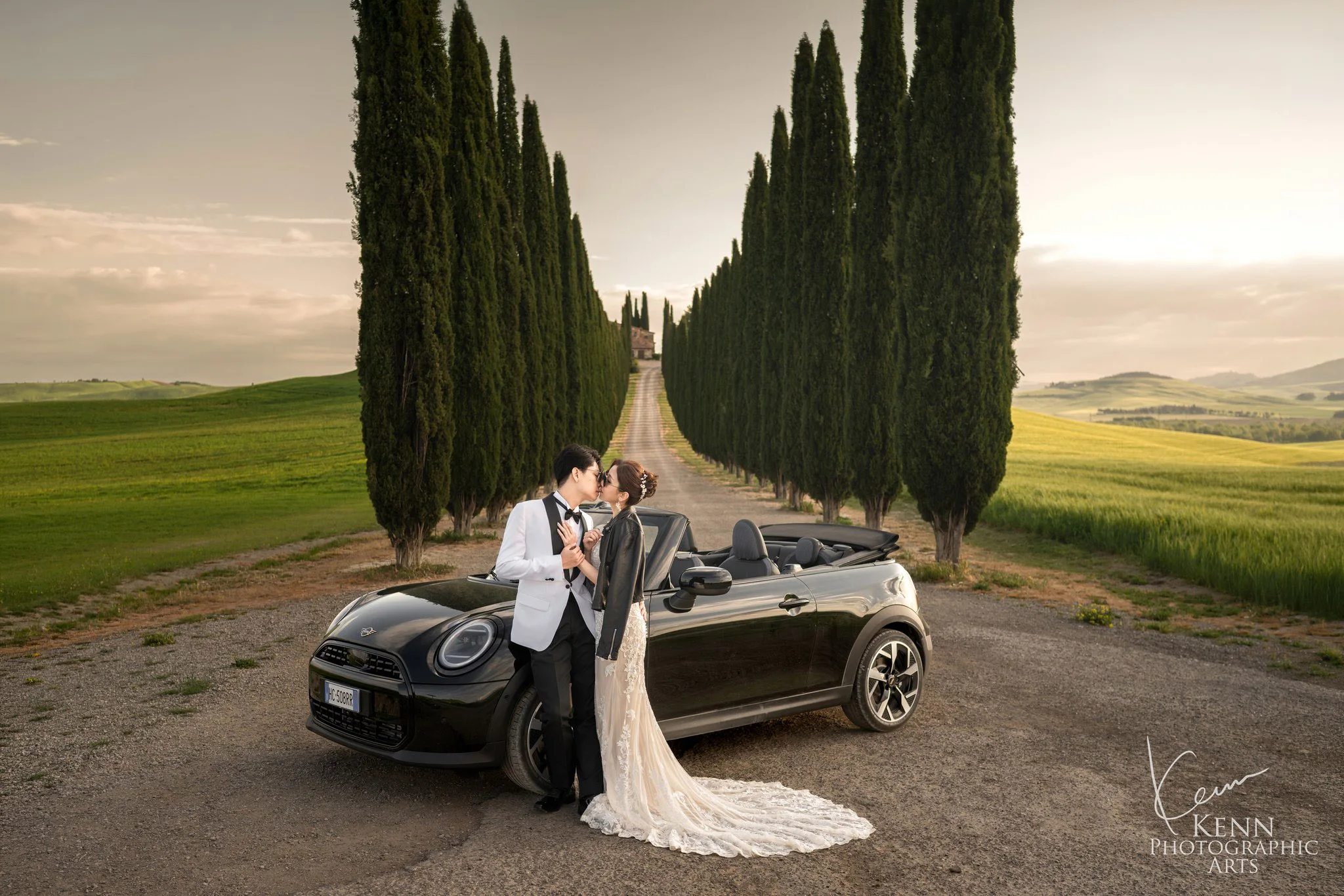 Wincy & Leo with a black convertible in a Tuscan cypress avenue — Florence & Tuscany pre-wedding by Kenn Photographic Arts