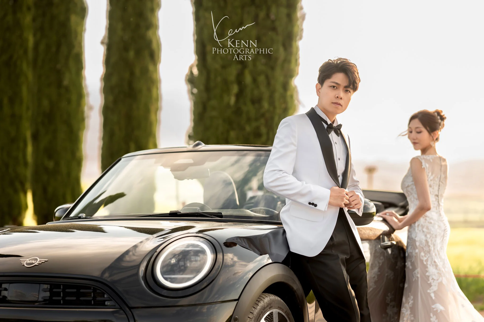 Leo leaning on the convertible as Wincy turns, beneath Tuscan cypresses — Florence & Tuscany pre-wedding by Kenn Photographic Arts