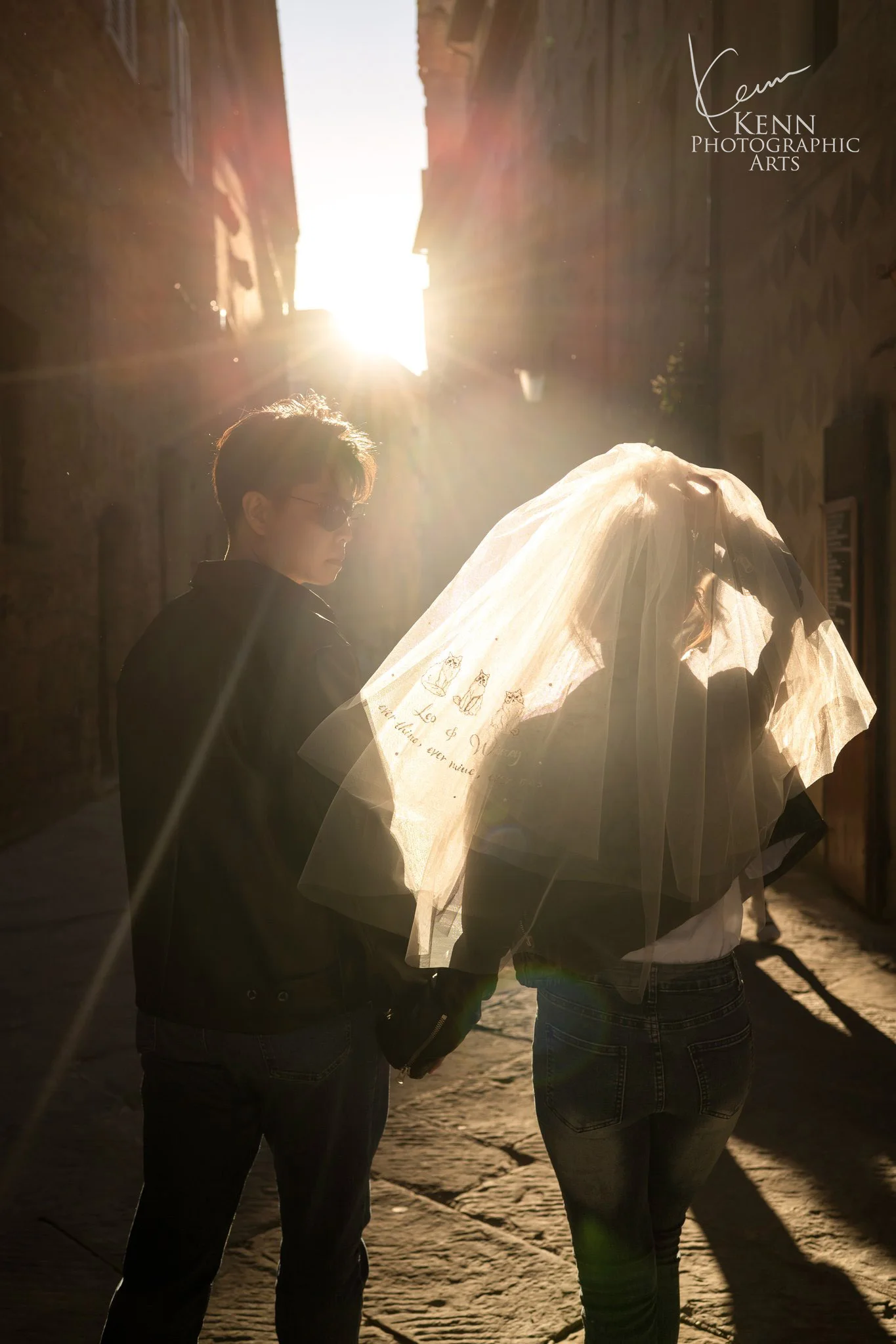 Wincy lifting her veil in a backlit Tuscan alley — Florence & Tuscany pre-wedding by Kenn Photographic Arts