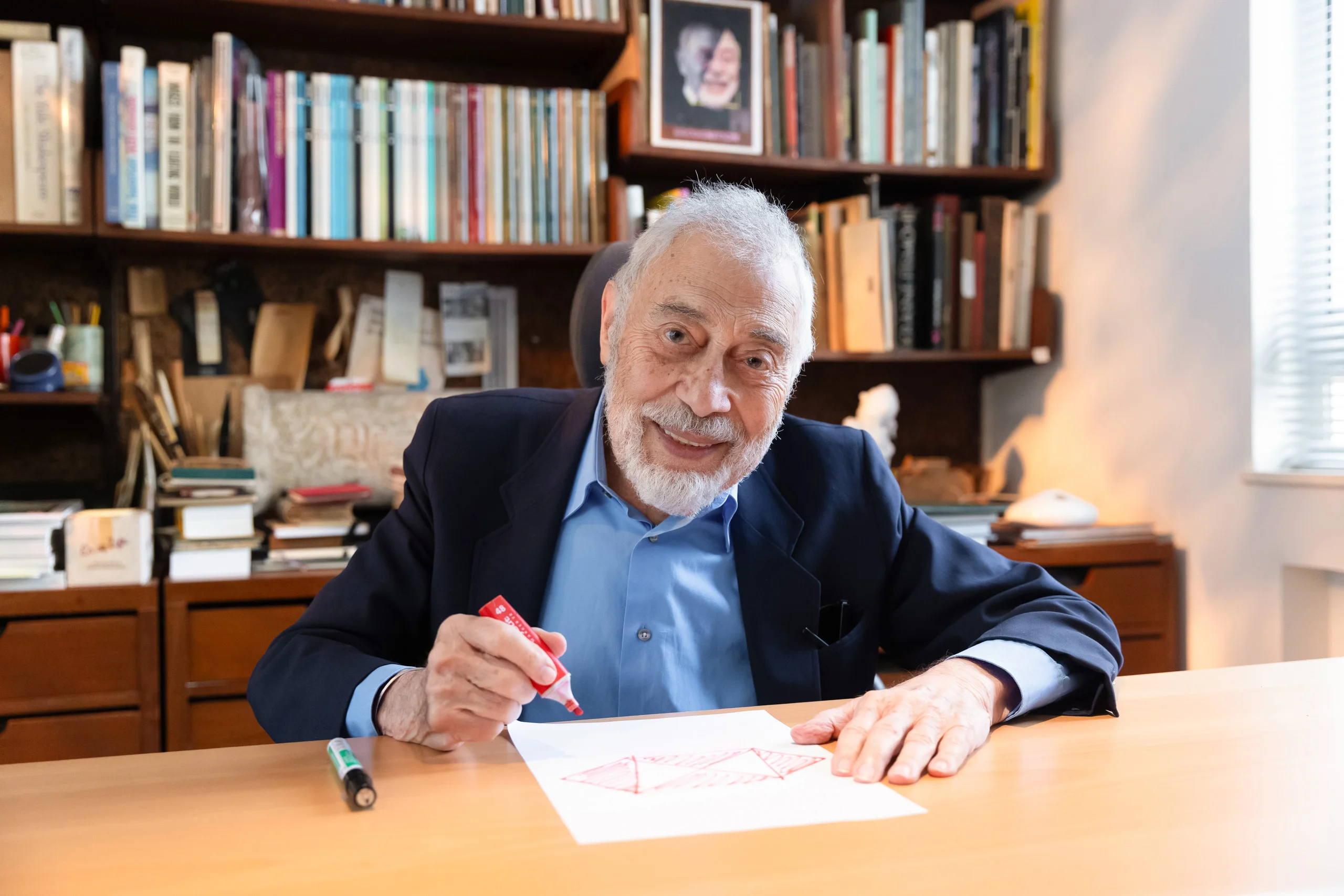 Portrait of a distinguished gentleman sketching at his desk in a book-lined study — commercial portrait by Kenn Photographic Arts