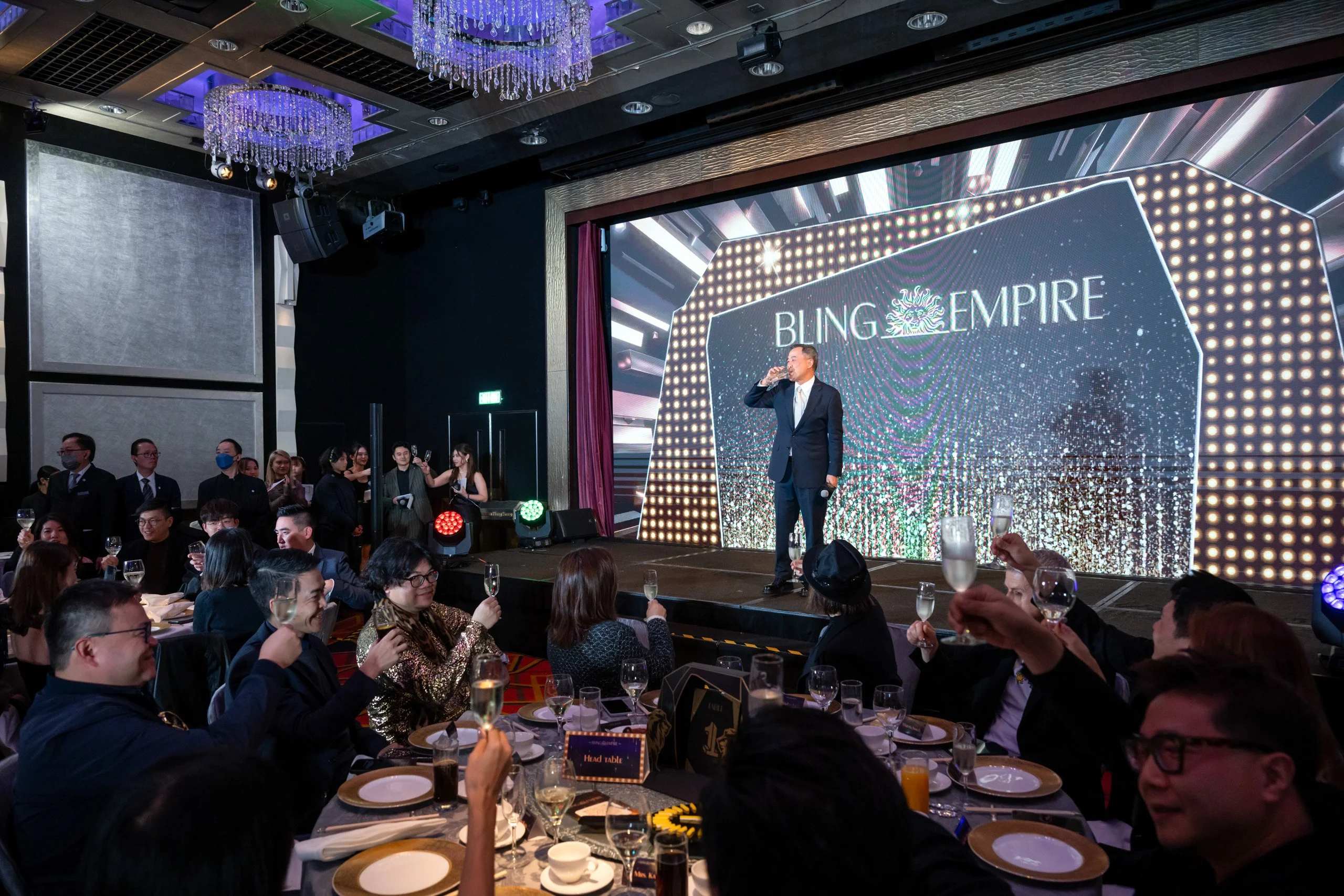 Guests at a gala dinner with a speaker on stage — event photography by Kenn Photographic Arts