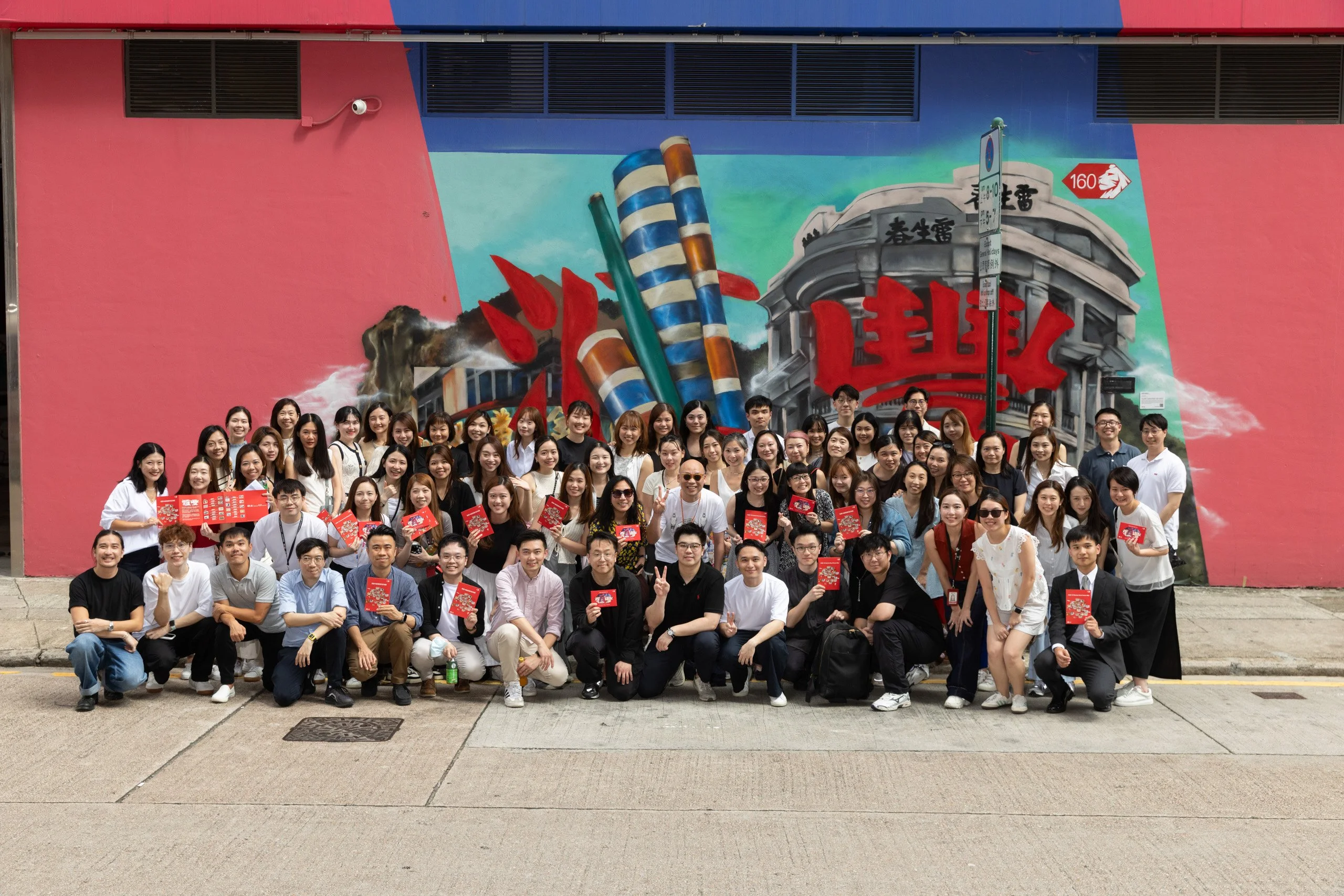 Large corporate team photo in front of a colourful street mural — corporate photography by Kenn Photographic Arts