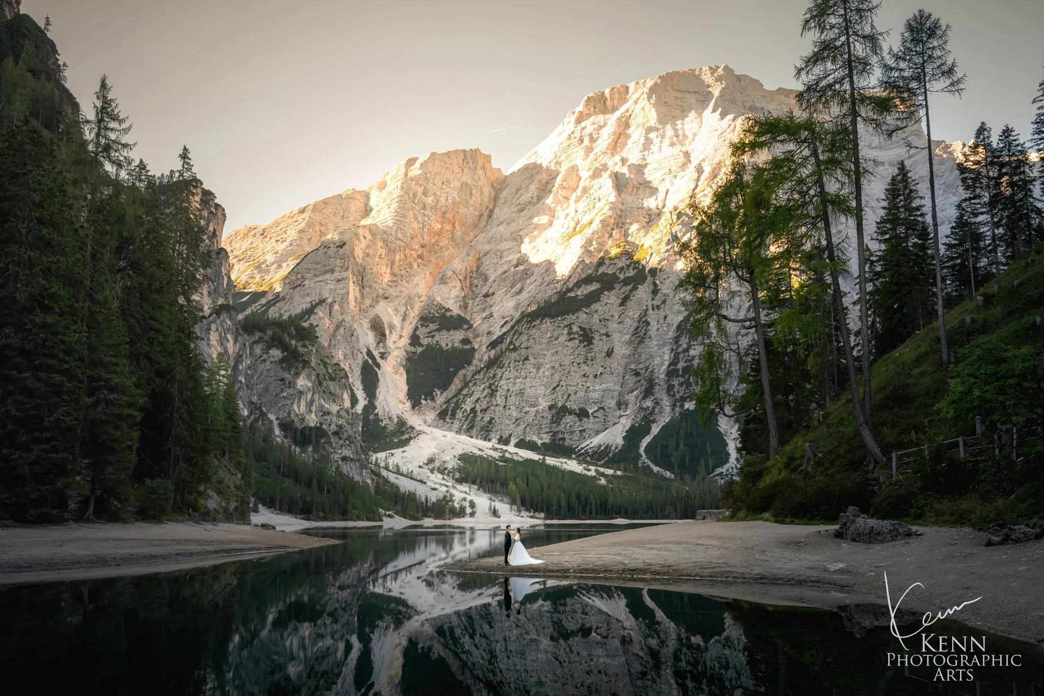 Lago di Braies in perfect reflection with Mable & Hon small on the shore — Dolomites pre-wedding by Kenn Photographic Arts
