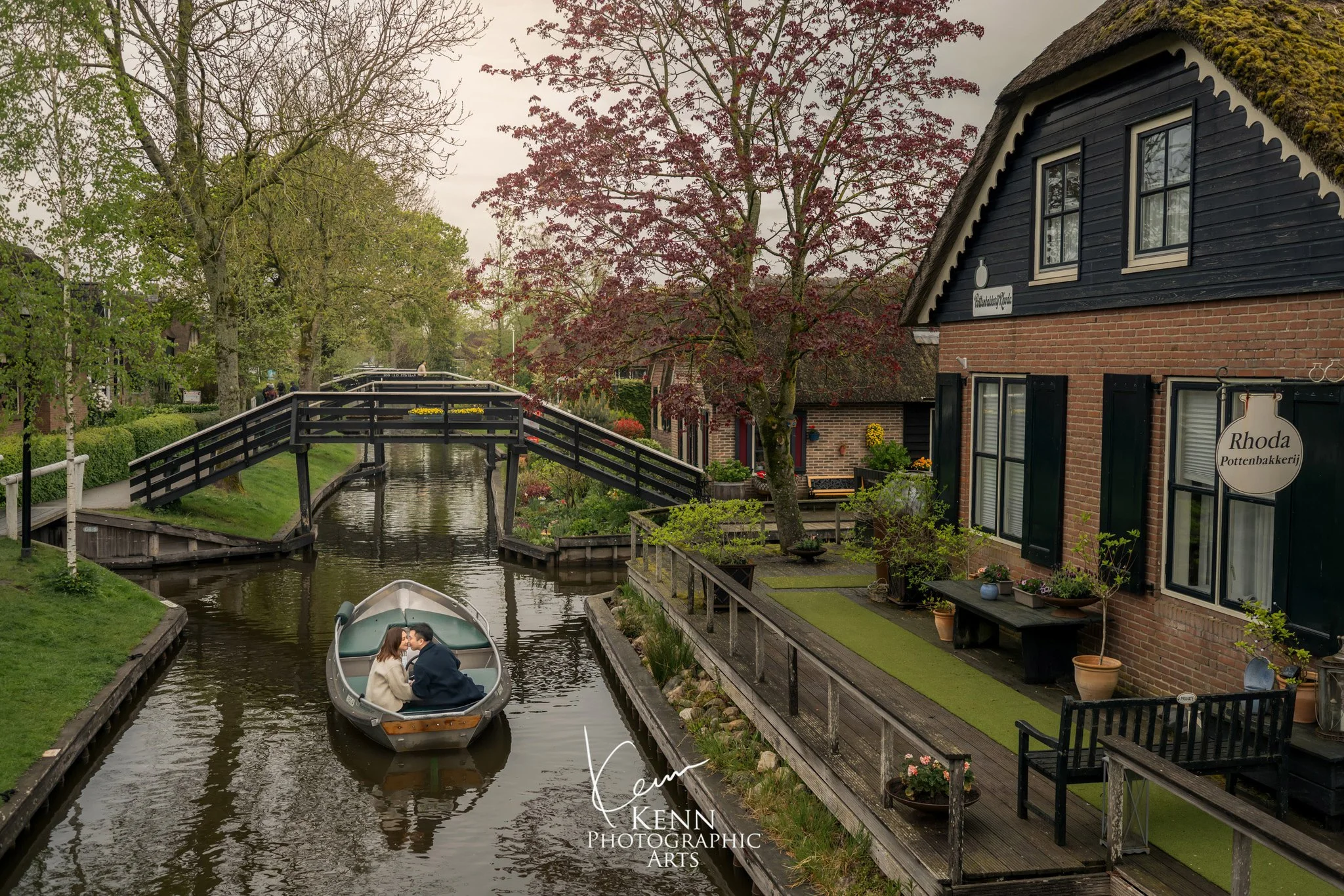 A boat gliding between thatched cottages and footbridges in Giethoorn — Netherlands pre-wedding by Kenn Photographic Arts