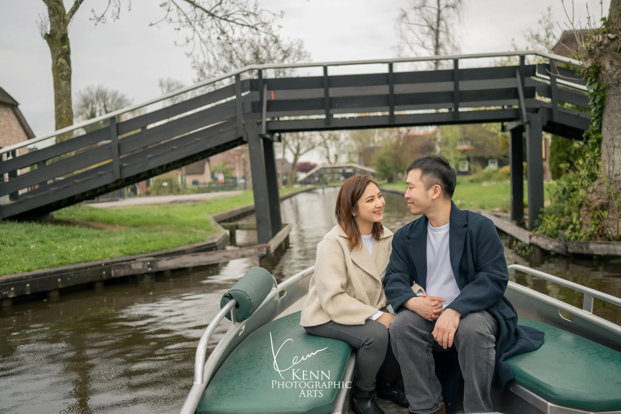 Michelle & Vincent in a boat beneath a wooden footbridge, Giethoorn — Netherlands pre-wedding by Kenn Photographic Arts
