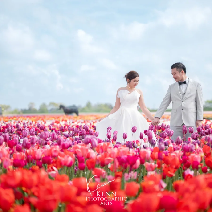 Michelle & Vincent walking hand in hand through Dutch tulip fields — Netherlands pre-wedding by Kenn Photographic Arts