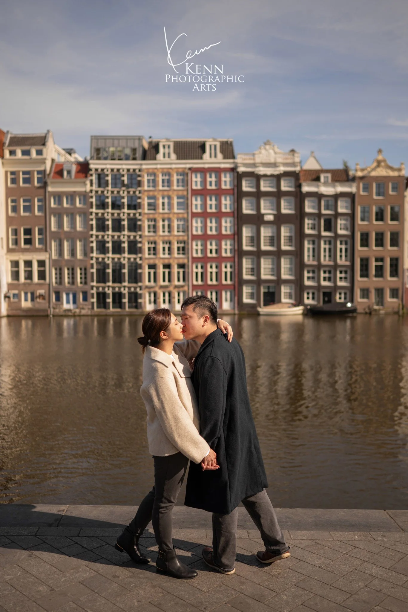Michelle & Vincent kissing by the water in front of Amsterdam canal houses — Netherlands pre-wedding by Kenn Photographic Arts