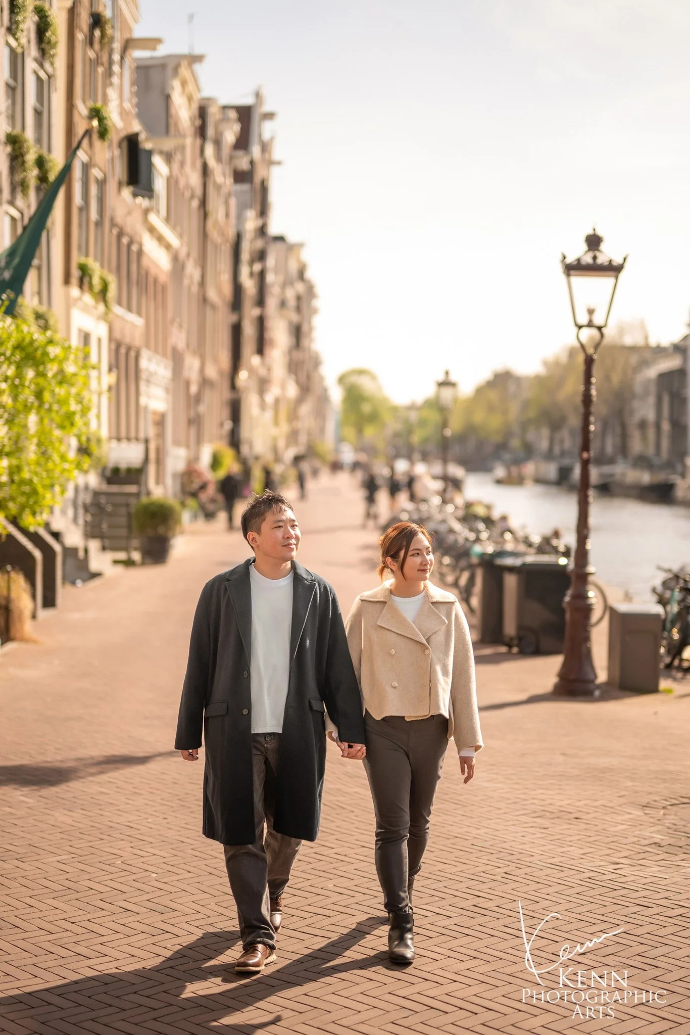 Michelle & Vincent walking along a sunny Amsterdam canal street — Netherlands pre-wedding by Kenn Photographic Arts